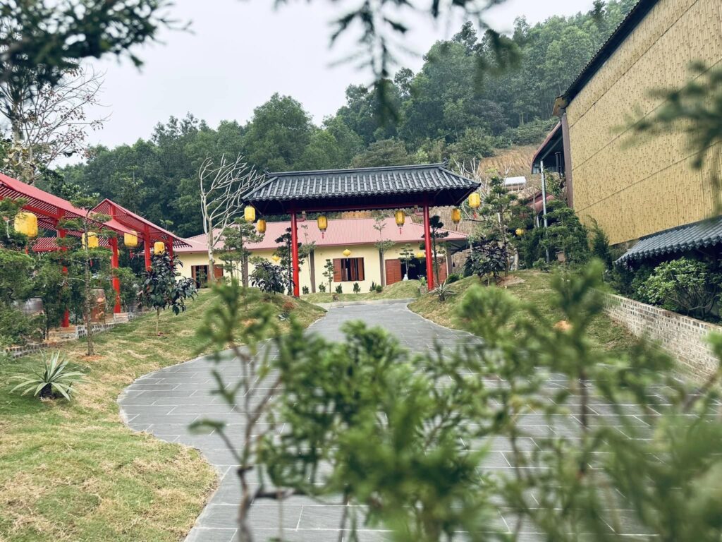 Cổng chính Chùa Cây Thị nhìn từ xa, hai bên công trình ốp tre nhân tạo