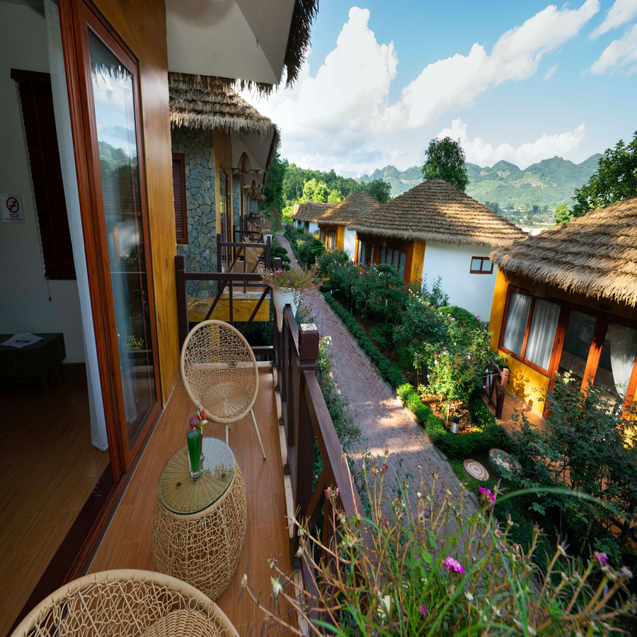 Ban công phòng nghỉ nhìn ra khu vườn và mái rơm nhân tạo