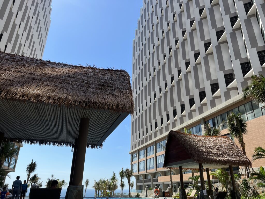 Mái lá nhân tạo tạo điểm nhấn mộc mạc, nổi bật giữa kiến trúc resort hiện đại.