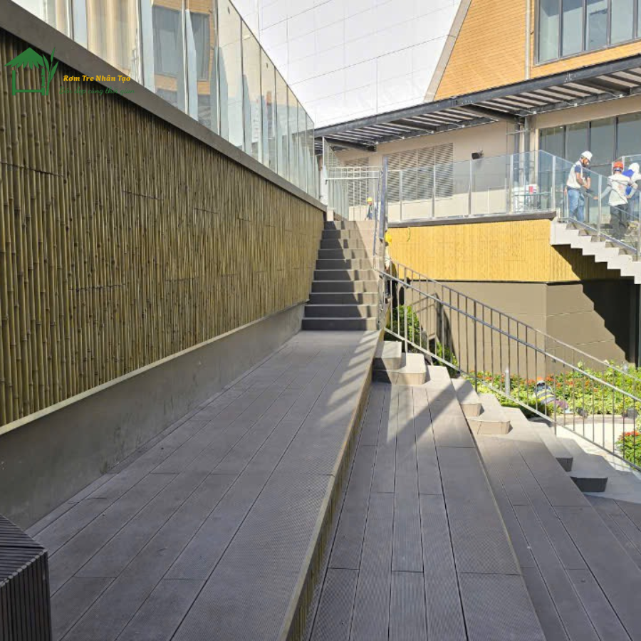 Lối đi có lan can kính kết hợp tường ốp tre nhân tạo tại Aeon Huế.